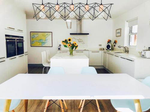 a kitchen with white tables and a vase of flowers at Sandpipers in Anstruther