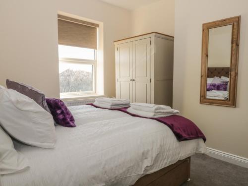 a bedroom with a bed with pillows and a mirror at 204 Sea View House in Redcar