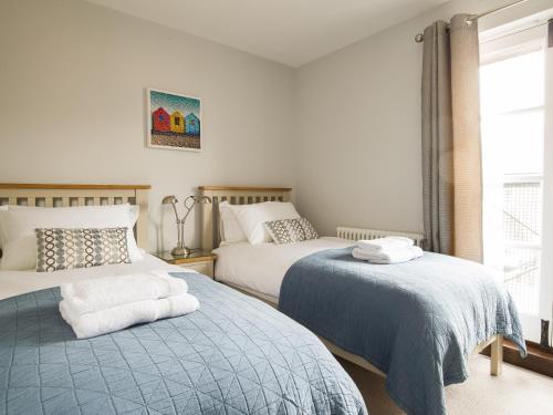 a bedroom with two beds and a window at Swan Cottage in Arundel