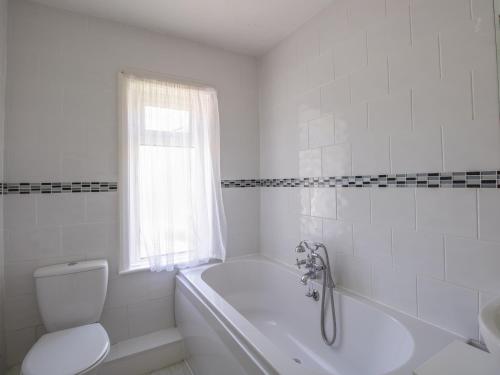 ein weißes Badezimmer mit einer Badewanne, einem WC und einem Waschbecken in der Unterkunft Waterson in Weymouth