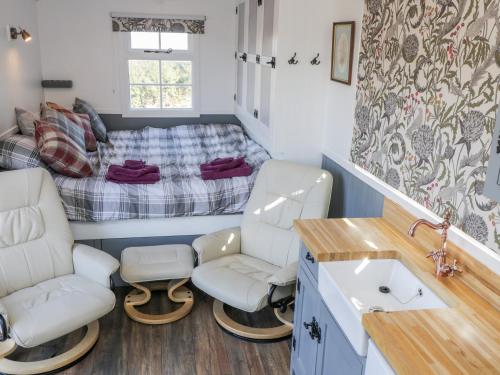 a bathroom with two chairs and a bed in a room at Lady Bird Retreat in Saltburn-by-the-Sea