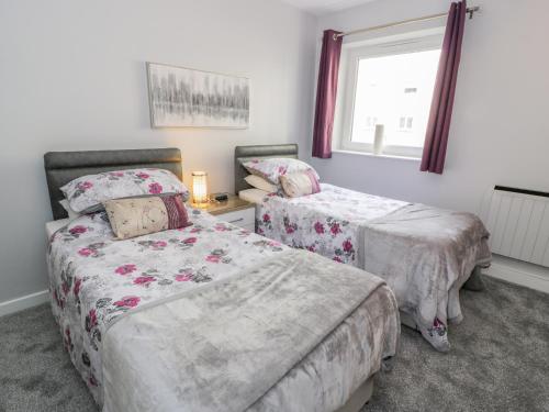 Un dormitorio con dos camas y una ventana. en Cumbrae View, en Largs