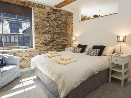 um quarto com uma cama grande e uma parede de tijolos em 8 The Pottery em Dartmouth