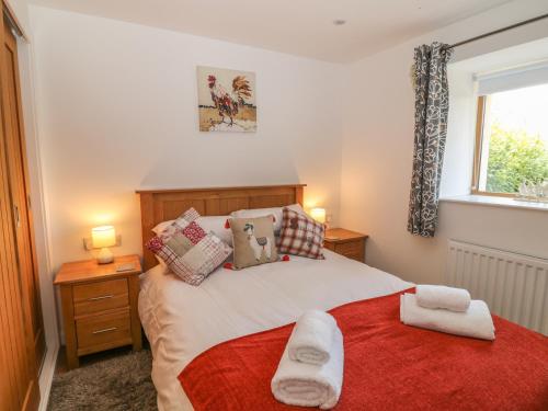 a bedroom with a bed with two towels on it at Whitsand in Saltash