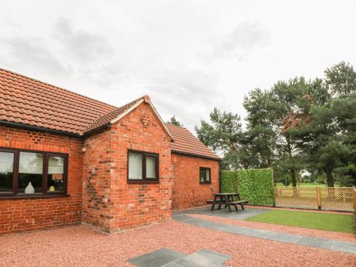 a brick house with a picnic table in front of it at The Stable in York