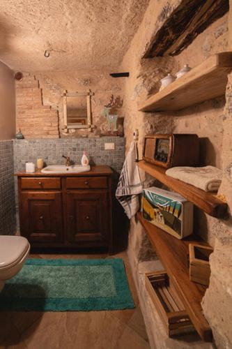 a stone bathroom with a sink and a toilet at Chalet Tre Santelle in Bossico