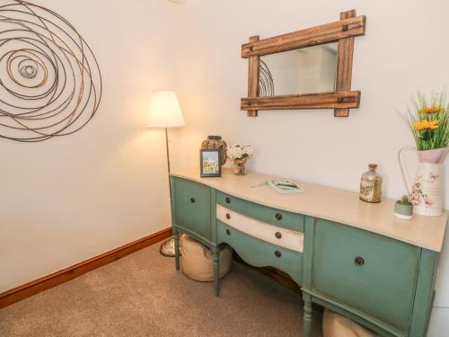 a room with a desk with a lamp and a mirror at 2 Bryn Eglwys in Porthmadog