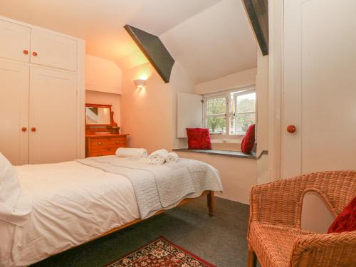 a bedroom with a white bed and a window at Churchgate Cottage in Bodmin
