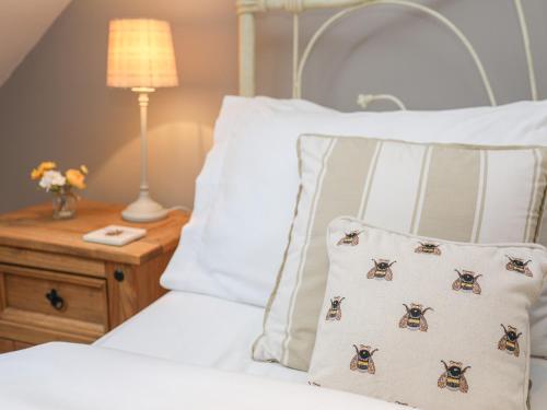a bedroom with a bed with a pillow and a lamp at Bwthyn Bach in Nefyn