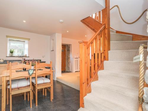 a kitchen and dining room with stairs and a table at Bwthyn Bach in Nefyn