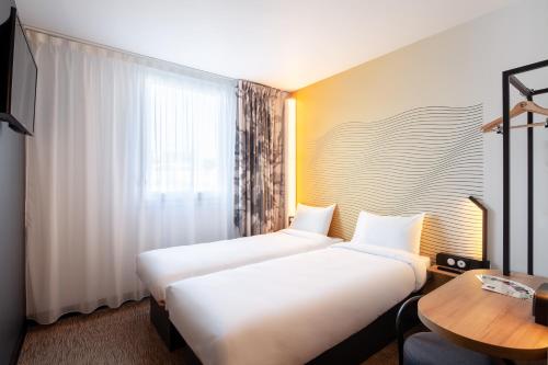 Ένα ή περισσότερα κρεβάτια σε δωμάτιο στο B&B HOTEL Paris Meudon Vélizy