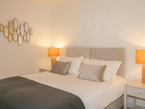 a bedroom with a large white bed with two lamps at Number 11 in Beauly