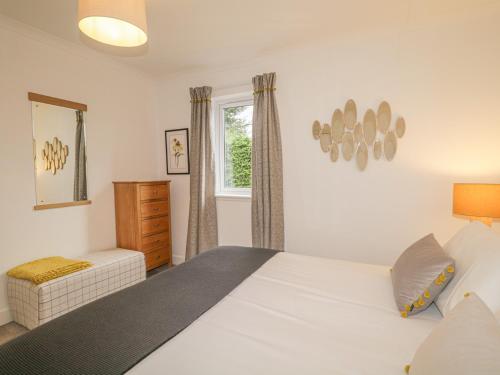 a bedroom with a white bed and a window at Number 11 in Beauly