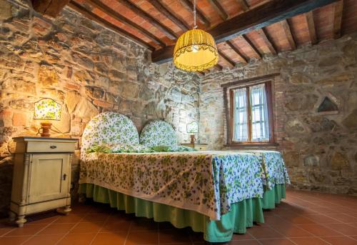 1 dormitorio con 1 cama en una pared de piedra en Cottage Casaglia en Paciano