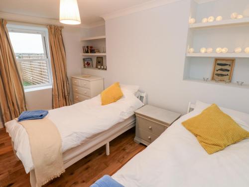 a bedroom with two beds and a window at Coeden Bach in Burry Port