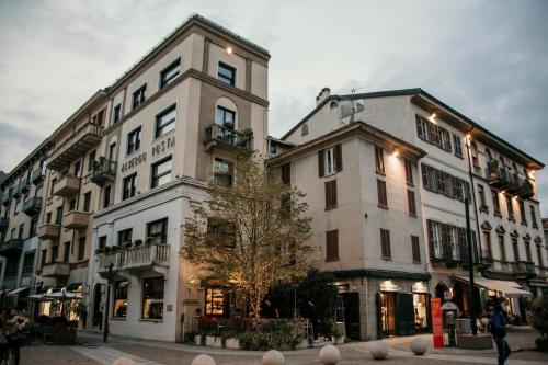dos edificios en una calle con gente caminando delante de ellos en Posta Design Hotel, en Como