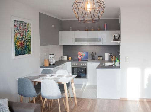 - une cuisine avec une table et des chaises blanches dans la chambre dans l'établissement Apartment von Schivelbusch, à Markkleeberg