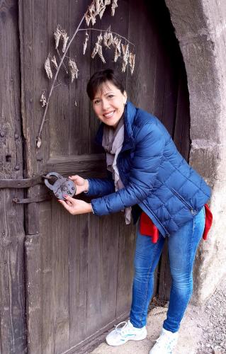 a woman is holding a stuffed animal in a wooden door at Vila Milenovic Rajacke Pivnice in Rajac