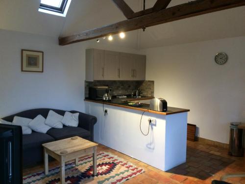 uma sala de estar com um sofá e uma cozinha em Starvegoose Cottage em Goudhurst