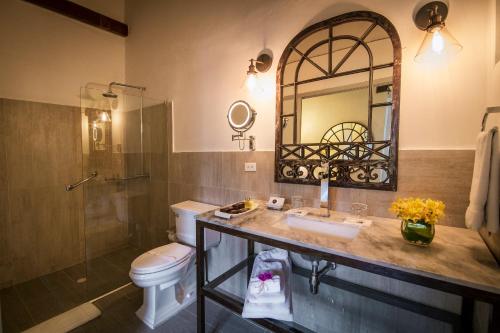 a bathroom with a sink and a toilet and a mirror at Hotel El Marqués by Faranda Boutique in Cartagena de Indias
