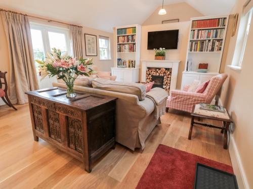 a living room with a couch and a fireplace at The Garden Cottage in Hexham