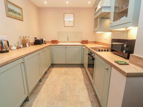 a kitchen with white cabinets and a counter top at The Garden Cottage in Hexham