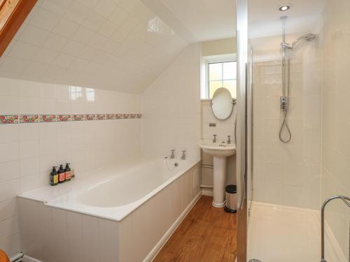 a white bathroom with a tub and a sink at Knights Cottage in Maidstone