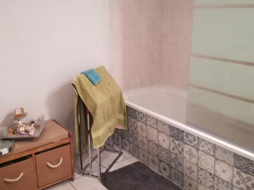 a bathroom with a tub and a towel on a chair at maison de vacances baie du Mont Saint Michel in Dol-de-Bretagne