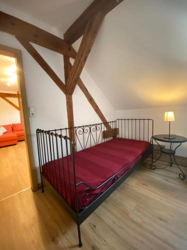 ein Schlafzimmer mit einem roten Bett in einem Zimmer in der Unterkunft Zur Lutherkanzel in Jena