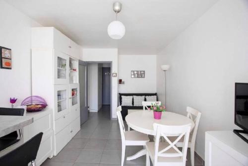 une cuisine et une salle à manger avec une table et des chaises blanches dans l'établissement LE SAPHYR, à Antibes