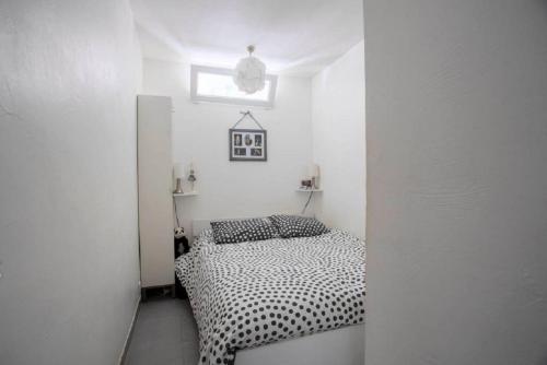 une chambre avec un lit dans une pièce blanche dans l'établissement LE SAPHYR, à Antibes