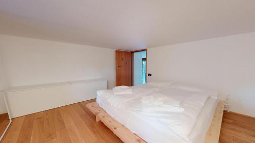 a bedroom with a white bed in a room at Bitabergh - Maloja in Maloja
