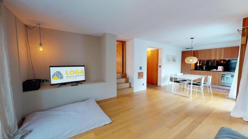 a living room with a bed and a television on a wall at Bitabergh - Maloja in Maloja