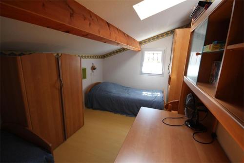 une petite chambre avec un lit et un bureau dans l'établissement Belle villa 5 couchages 2 chambres 2 terrasses piscine commune dans résidence securisée à 200m de la mer LRMA23, à Portiragnes