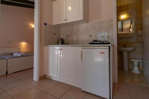 - une cuisine avec des placards blancs et un évier dans l'établissement Andreas House, à Dassia