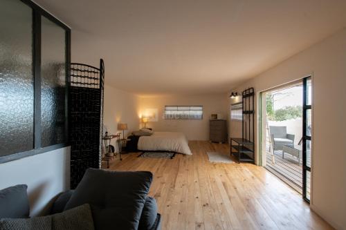 a living room with a couch and a bed in a room at Spa Les Jardins De Chiron Lodges et Tiny House dans le sud in Sauve