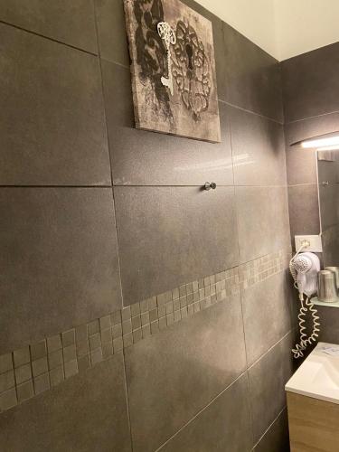 a bathroom with a shower with a tile wall at B&B Mini Hotel Incity-close train station and port- in Salerno