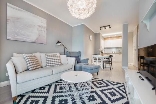 a living room with a couch and a table at Apartamenty Sun & Snow Cztery Oceany in Gdańsk