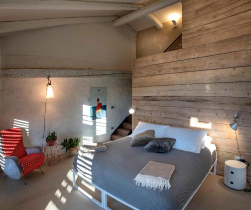 een slaapkamer met een bed en een houten muur bij ROSTAGNI1834: VILLA WITH 2 APTS AND POOL IN THE BAROLO REGION in Novello