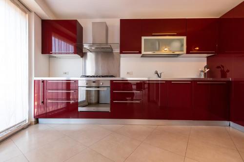 uma cozinha com armários vermelhos e um micro-ondas em Diamond Rooftop by Babylon Stay em Nápoles
