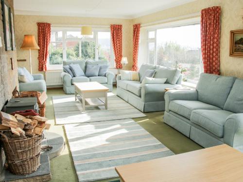 a living room with blue couches and a table at Lane House in Bishops Castle