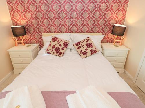 sypialnia z białym łóżkiem i 2 szafkami nocnymi w obiekcie Vallum Kiosk w mieście Hexham