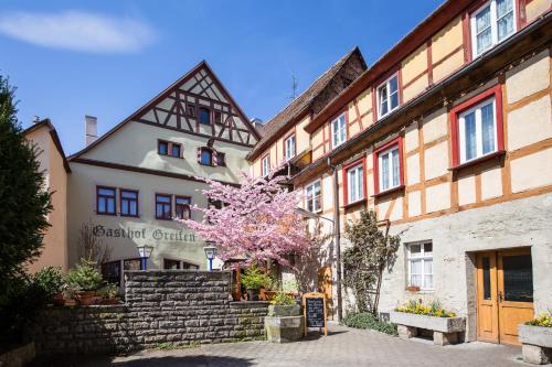 un bâtiment avec un arbre en face dans l'établissement Hotel-Gasthof Goldener Greifen, à Rothenburg ob der Tauber
