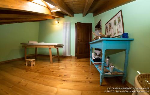 a room with a blue table and a wooden floor at Il Casolare Bioenergetico in Albareto