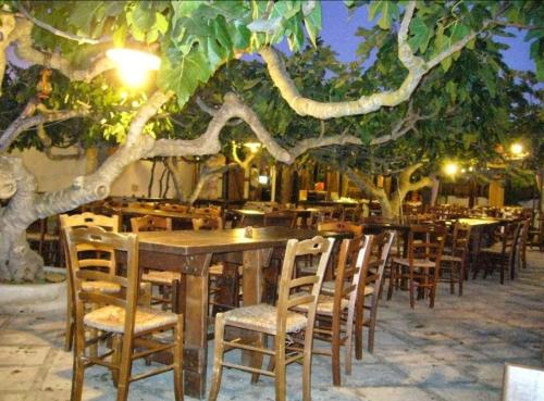 un ristorante con tavoli e sedie sotto gli alberi di Stanza B&B Posto Rosso a Torre San Giovanni Ugento