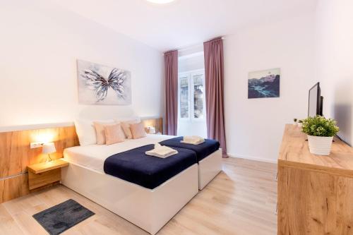 a bedroom with a bed and a television in it at Apartments Fiorello in Rijeka