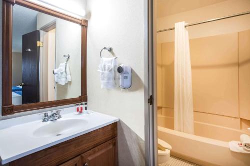 uma casa de banho com um lavatório e um chuveiro em Travelodge by Wyndham Colorado Springs Airport/Peterson AFB em Colorado Springs