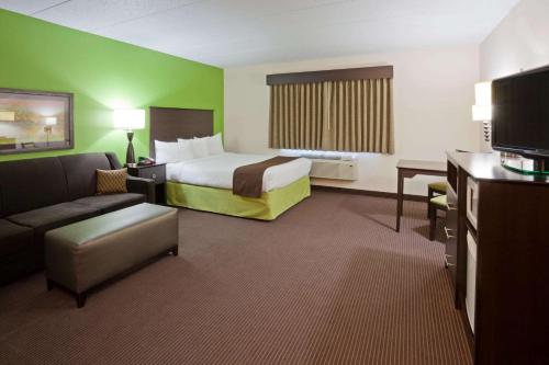 a hotel room with a bed and a couch at AmericInn by Wyndham Crookston U of M Crookston in Crookston