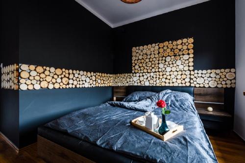 ein Schlafzimmer mit einem Bett mit einem Tisch und einer Blume darauf in der Unterkunft Blue House Warsaw Center in Warschau