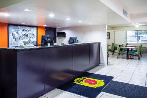 a bar in an office with a table and chairs at Super 8 by Wyndham Giddings in Giddings